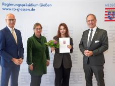 Foto: RP Gießen | Ministerialdirigent Andreas Monz (links), Regierungspräsident Dr. Christoph Ullrich (rechts) und Schulleiterin Beatrix Bunse (2. v. l.) gratulierten Kardelen Kadir (3. v. l.).