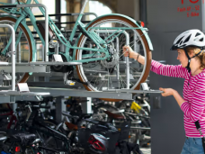 Fahrradgarage: Frau hebt ihr Fahrrad in die Garage