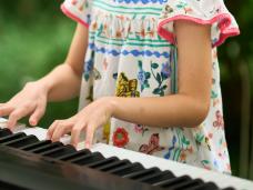 Junge Musikschülerin am Keyboard im Johanniter-Garten