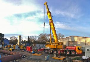 Der Aufbau eines 300 t Mobilkrans kündigt die ersten Betonfertigteilarbeiten an.